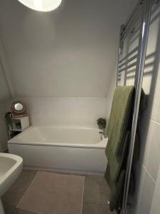 Un baño blanco con bañera y lavabo. en Seaside apartment, en Bexhill-on-Sea