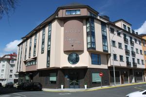 a building with a clock on the side of it at Hotel Pontes do Eume in Puentes de García Rodríguez