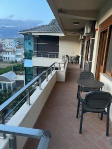 a balcony with tables and chairs on a building at Manga Luxury Apartments - 2 Bedrooms in Gjirokastër