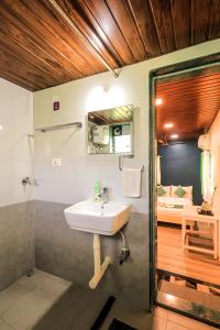 a bathroom with a sink and a bedroom with a bed at Kokanwadi Resort in Ratnagiri +52 photos
