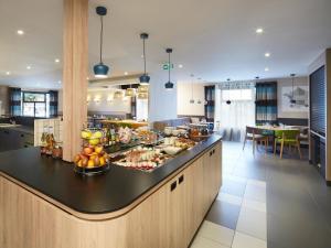 a kitchen with a counter with food on it at Campanile Le Mans - Arnage in Arnage