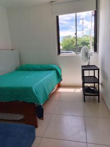 a bedroom with a bed and a window with a fan at APARTAMENTO RICAURTE Cund in Ricaurte +10 photos