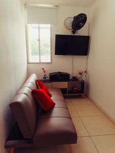 a living room with a brown couch and a television at APARTAMENTO RICAURTE Cund in Ricaurte