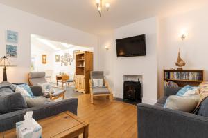 uma sala de estar com dois sofás e uma TV em Arwerydd em Aberporth