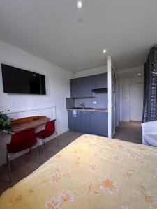 una camera con letto e tavolo e una cucina di La douce escale ad Angoulême