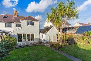 uma casa branca com uma palmeira no quintal em Arwerydd em Aberporth