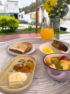 Oasis urbano! Apartamento Geminis complejo في سان نيكولاس دي لوس أرويوس: طاولة مع أطباق من الطعام وكأس من عصير البرتقال