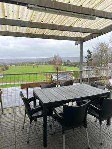 ein Holztisch und Stühle auf einer Terrasse in der Unterkunft Laventure in Aywaille