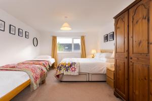 um quarto com duas camas e uma janela grande em Arwerydd em Aberporth