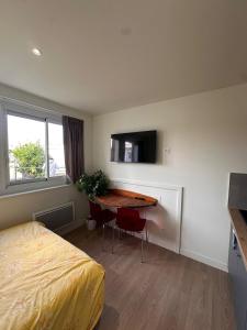 una camera da letto con un letto e una scrivania con una televisione di La douce escale ad Angoulême