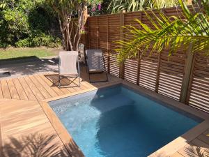 a small swimming pool with two chairs and a fence at PomKalbas - Les lodges Racines é Zel in Vieux-Fort +24 photos
