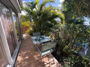 PomKalbas - Les lodges Racines é Zel في Vieux-Fort: فناء مع طاولة وكرسي على شرفة