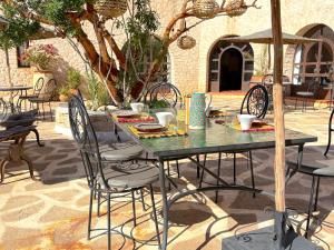 a table with chairs and an umbrella on a patio at Palais Tiyana in Al Ghar +64 photos