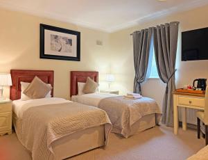 a hotel room with two beds and a window at Waterloo Lodge in Dublin