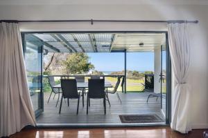a dining room with a table and chairs on a deck at Island View in Hayborough