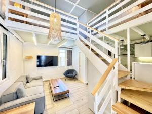 a living room with stairs leading up to a loft at The Square House - Berbara in Al Ḩulwah