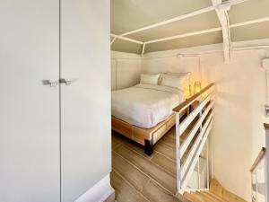 a small bedroom with a bed and a staircase at The Square House - Berbara in Al Ḩulwah +30 photos
