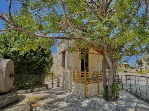 a building with a tree in front of a fence at The Square House - Berbara in Al Ḩulwah