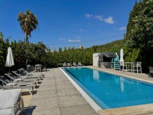 a swimming pool with lounge chairs and a palm tree at The Square House - Berbara in Al Ḩulwah