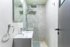 Residence 4 - Comfy Apts & Balconies in Mar Mikhael في Al Mudawwar: حمام أبيض مع حوض ودش +34 صورة