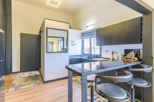 Residence 4 - Comfy Apts & Balconies in Mar Mikhael في Al Mudawwar: مطبخ مع طاولة و كرسيين