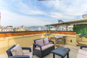 Residence 4 - Comfy Apts & Balconies in Mar Mikhael في Al Mudawwar: فناء مع كراسي وطاولة على السطح