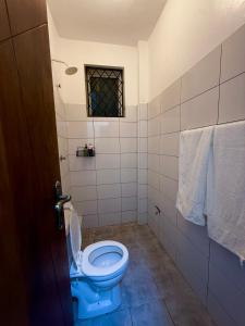 a bathroom with a blue toilet and a window at Nyali 3 Bedroom Apartment Skyview in Mombasa +38 photos