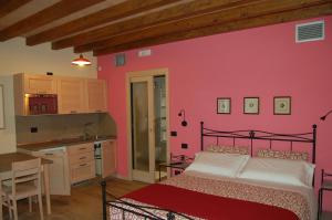 OmeにあるAgriturismo I Due Angeliのピンクの壁のベッドルーム(ベッド1台付)、キッチン