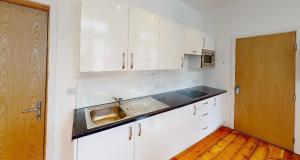a kitchen with white cabinets and a sink at Modern Studio, 1st floor, King Street Views in Nottingham