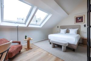 a bedroom with a white bed and a window at Le Catherine by Sweett in Brussels +5 photos