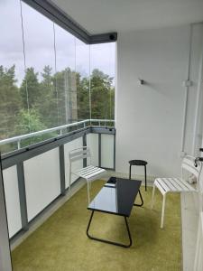 een lege kamer met 2 stoelen en ramen bij Kotimaailma - Valoisa ja tilava neliö in Turku