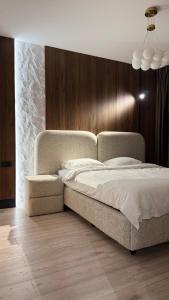 a bedroom with a large bed and a wooden wall at Vanilla Studio Apartment 2 in Timişoara