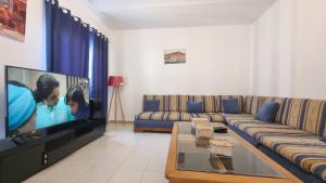 un soggiorno con divano e TV a schermo piatto di Confort & Soleil Akid Lotfi a Orano