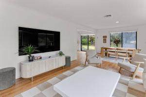 a living room with a large tv and a table at Saltwater Shack in Anglesea
