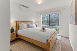 a bedroom with a large bed and a window at Saltwater Shack in Anglesea