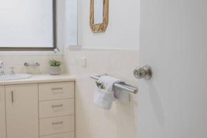 a bathroom with a sink and a towel hanging on the door at Saltwater Shack in Anglesea +30 photos