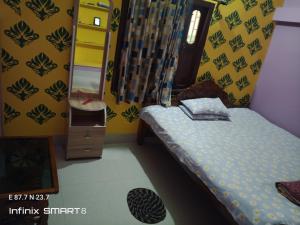 a small bedroom with a bed and a mirror at Swpnaneer home stay in Shānti Niketan