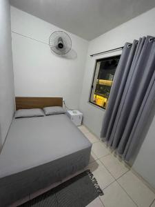a bedroom with a bed and a window with a fan at Hotel Colombo in São Lourenço +15 photos