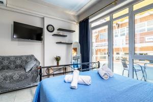 干尼亚阿伦娜公寓的卧室里有一张铺着蓝色床单的床和一扇窗户