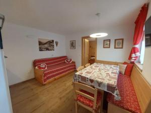 Un dormitorio con una cama y una mesa y sillas. en BAITA CUCOL: APPARTAMENTO CON GIARDINO PRIVATO, en Cogolo