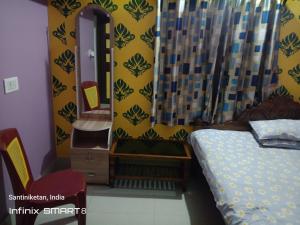 a bedroom with a bed and a mirror at Swpnaneer home stay in Shānti Niketan