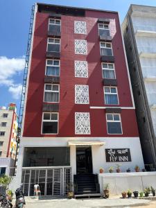 a red building with the front of it at Fly Inn Bangalore Airport in Muthugadahalli