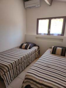 Dos camas una al lado de la otra en una habitación. en Gite Le Roma, en Oppède