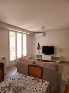Una sala de estar con un sofá y un televisor. en Gite Le Roma, en Oppède 25 fotos más