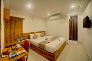 a hotel room with a bed and a table with a table at Fly Inn Bangalore Airport in Muthugadahalli +49 photos
