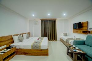 a hotel room with two beds and a couch at Fly Inn Bangalore Airport in Muthugadahalli