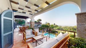 a patio with a couch and chairs on a balcony at Villa Ambiance in Kyrenia