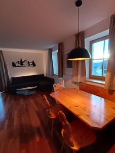 Apartment Panorama Val di Non في San Felice: غرفة معيشة مع طاولة خشبية وأريكة