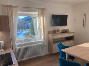 a living room with a window and a table with chairs at Haus Werner, Ferienwohnung mit Sommercard in Ramsau am Dachstein