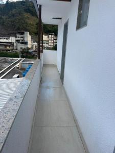 a walkway on the side of a white building at Família Ebeneze in Nova Friburgo